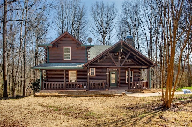 1225 Pitts Chapel, Newborn, GA 30056 - view of front of house with log exterior, covered porch, and a chimney