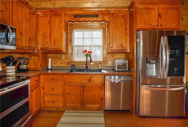 1225 Pitts Chapel, Newborn, GA 30056 - kitchen with stainless steel appliances, a sink, brown cabinetry, and wood finished floors