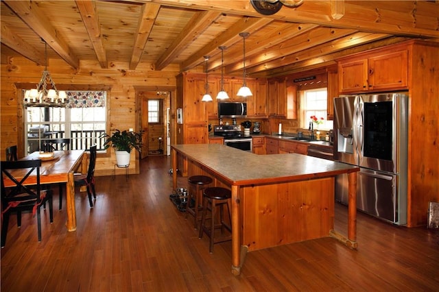 1225 Pitts Chapel, Newborn, GA 30056 - kitchen featuring stainless steel appliances, brown cabinets, beamed ceiling, a chandelier, and wooden walls