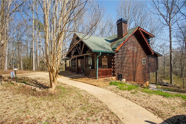 1225 Pitts Chapel, Newborn, GA 30056 - view of side of home with a porch, a chimney, log siding, and roof with shingles