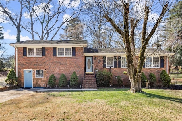 split level home with brick siding, concrete driveway, and a front yard