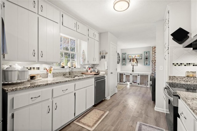 kitchen featuring white cabinetry, electric range oven, light wood-style floors, dishwasher, and backsplash