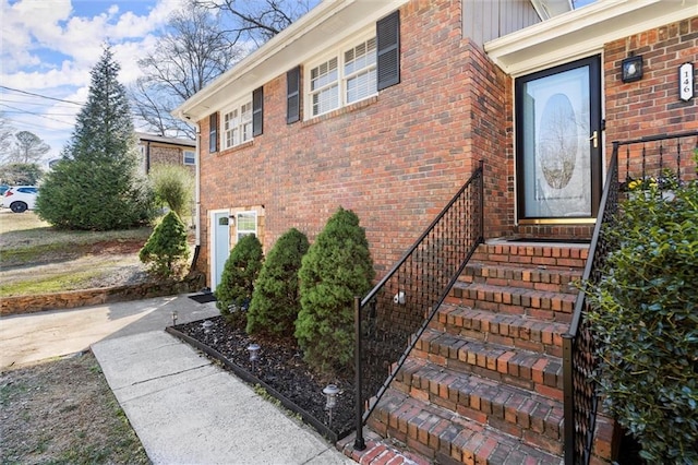 view of exterior entry featuring brick siding