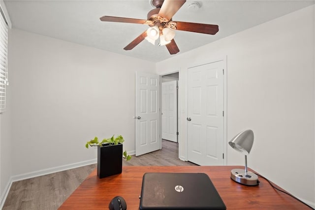 office area featuring a ceiling fan, wood finished floors, and baseboards