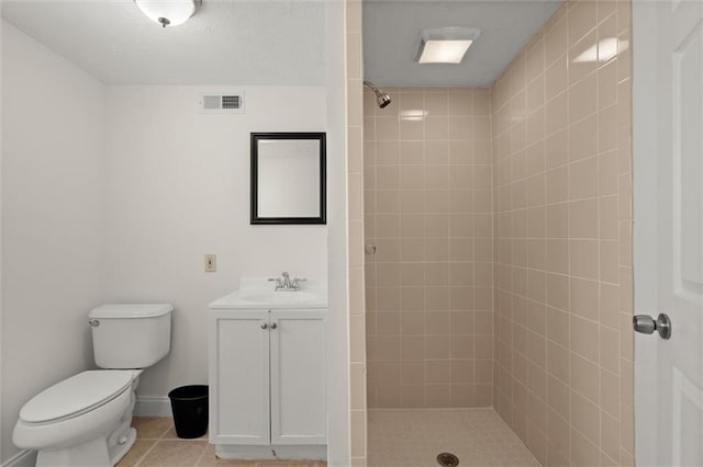 full bathroom with visible vents, toilet, a tile shower, tile patterned floors, and vanity