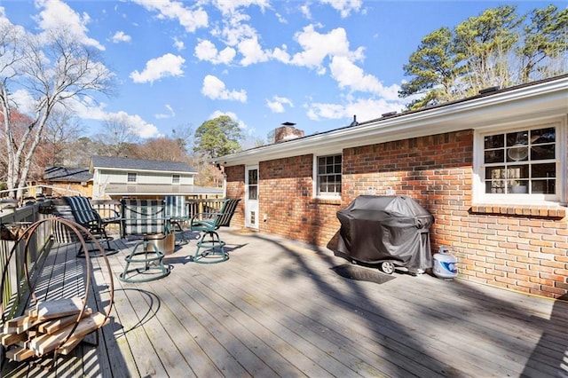 deck with grilling area and outdoor dining area