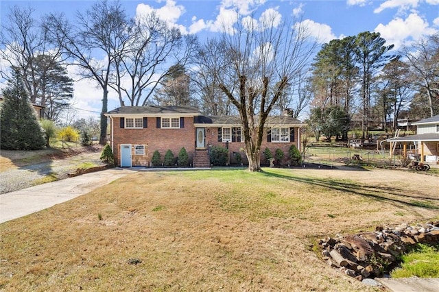 split level home featuring a front lawn, brick siding, and driveway