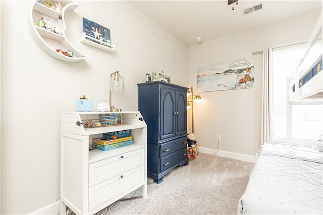 bedroom featuring visible vents, light carpet, and baseboards