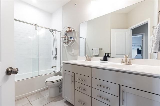 bathroom featuring bath / shower combo with glass door, double vanity, a sink, and tile patterned floors