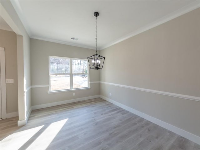 unfurnished dining area with crown molding, a chandelier, and light hardwood / wood-style floors