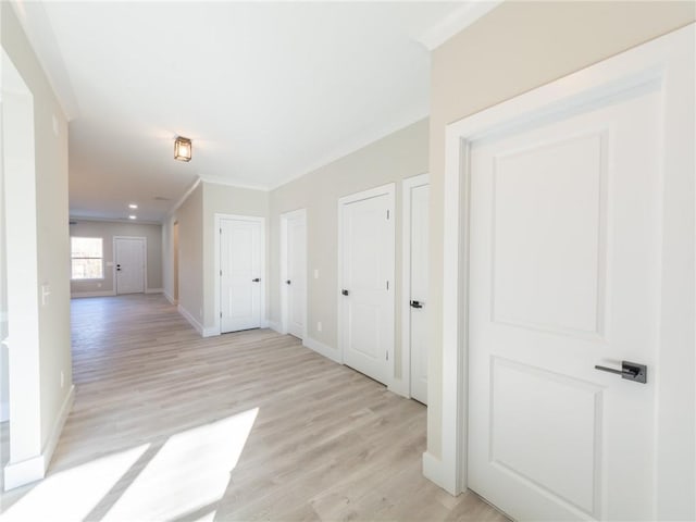 hallway featuring light wood-type flooring and crown molding