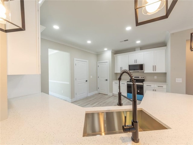 kitchen with stainless steel range with electric stovetop, white cabinetry, crown molding, light stone counters, and sink