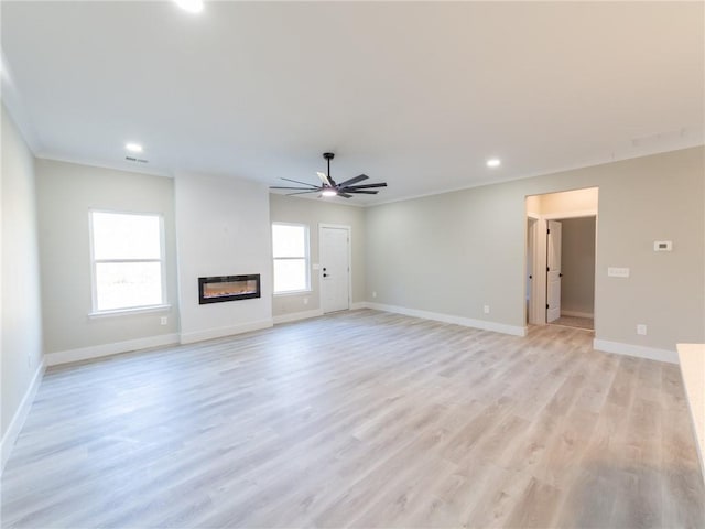 unfurnished living room with ceiling fan, light wood-type flooring, and crown molding