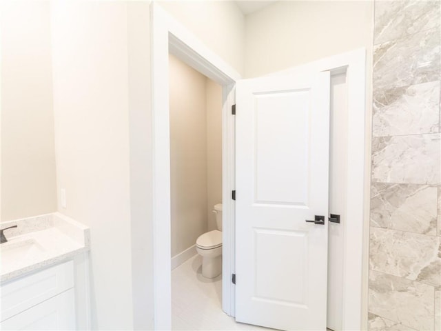 bathroom featuring toilet, tile patterned flooring, and vanity