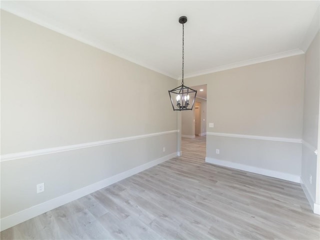 unfurnished dining area featuring light wood-type flooring, crown molding, and a chandelier