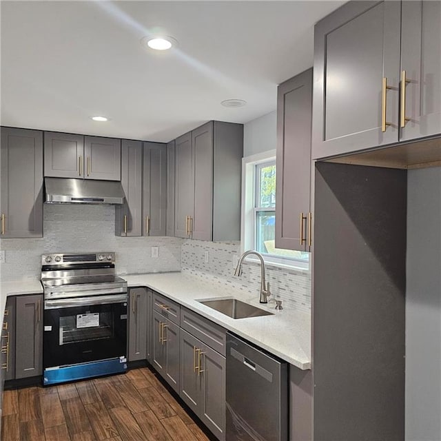 487 Eastside Dr, Dacula, GA 30019 - kitchen with appliances with stainless steel finishes, under cabinet range hood, gray cabinetry, a sink, and decorative backsplash