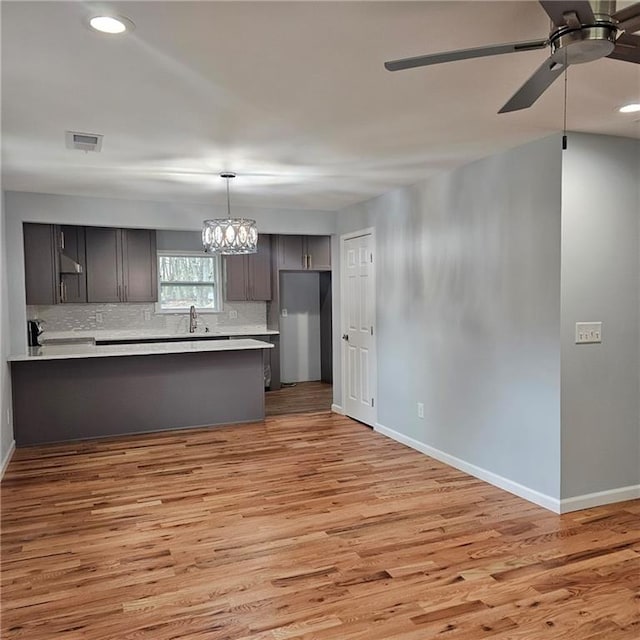 487 Eastside Dr, Dacula, GA 30019 - kitchen featuring baseboards, ceiling fan, light wood-style flooring, a peninsula, and light countertops