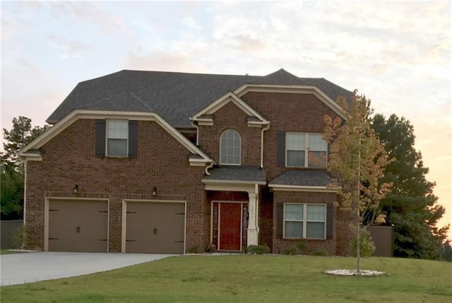 craftsman-style house featuring concrete driveway, brick siding, a lawn, and an attached garage