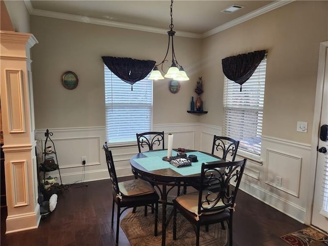 dining area with visible vents, crown molding, dark wood-style floors, ornate columns, and a wainscoted wall