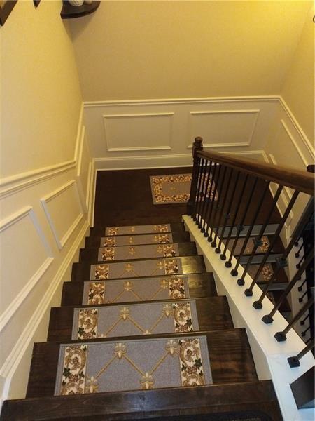 stairs featuring wainscoting and a decorative wall