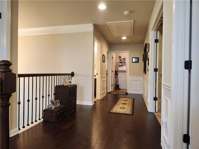 hallway with recessed lighting, wainscoting, a decorative wall, and wood finished floors