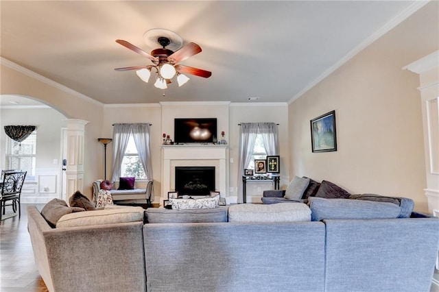 1211 Chapel Estates Way, Dacula, GA 30019 - living area with arched walkways, a ceiling fan, a fireplace, healthy amount of natural light, and ornamental molding