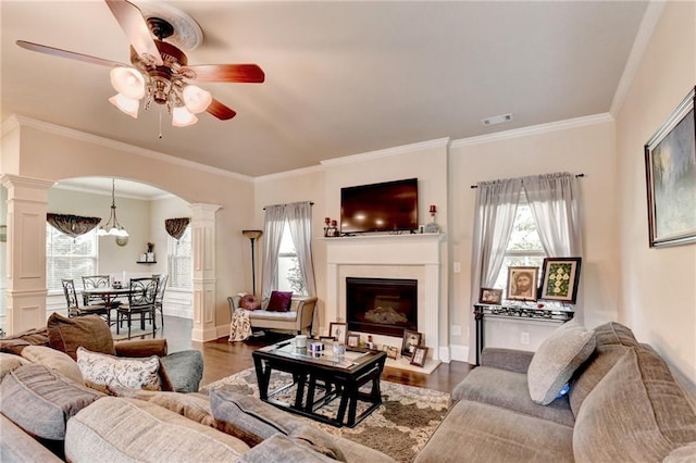 1211 Chapel Estates Way, Dacula, GA 30019 - living area featuring decorative columns, a ceiling fan, arched walkways, wood finished floors, and a fireplace with raised hearth