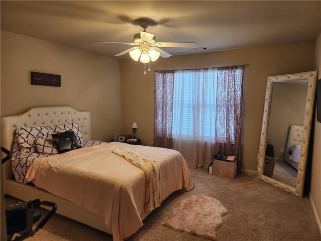 carpeted bedroom featuring a ceiling fan and visible vents