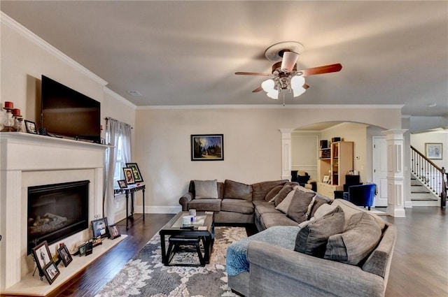 1211 Chapel Estates Way, Dacula, GA 30019 - living area featuring decorative columns, ceiling fan, arched walkways, a glass covered fireplace, and wood finished floors