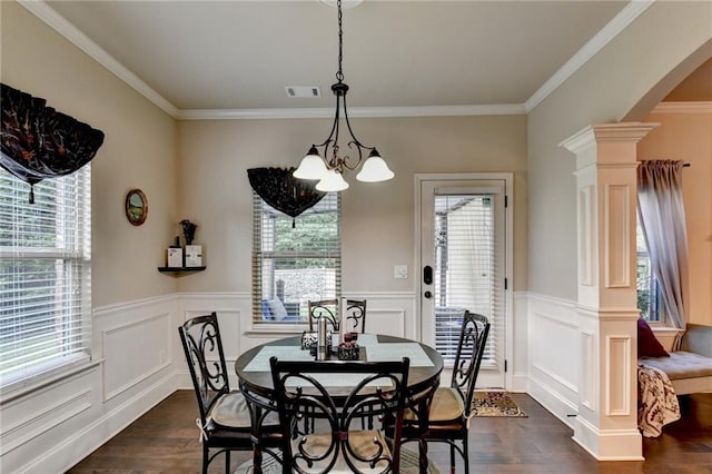 1211 Chapel Estates Way, Dacula, GA 30019 - dining area featuring dark wood finished floors, arched walkways, a chandelier, ornate columns, and wainscoting