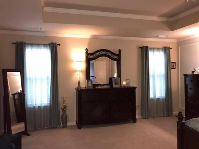 bedroom featuring a raised ceiling, ornamental molding, and light carpet