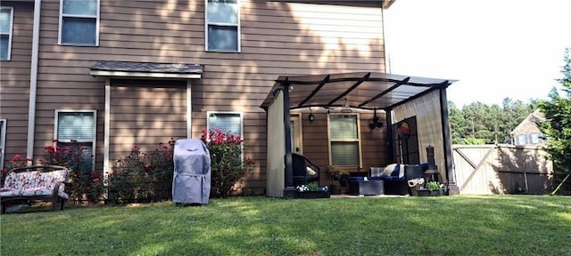 rear view of house featuring fence, a pergola, and a lawn