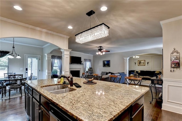 1211 Chapel Estates Way, Dacula, GA 30019 - kitchen featuring arched walkways, ceiling fan, open floor plan, a fireplace, and a wainscoted wall