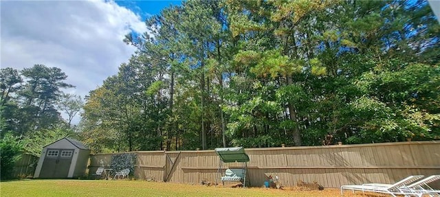 view of yard with fence, an outdoor structure, and a shed