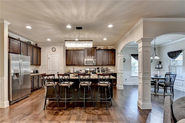 1211 Chapel Estates Way, Dacula, GA 30019 - kitchen featuring stainless steel appliances, ornate columns, arched walkways, dark brown cabinetry, and crown molding