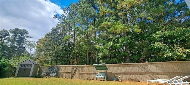 exterior space featuring a storage unit, a fenced backyard, and an outbuilding