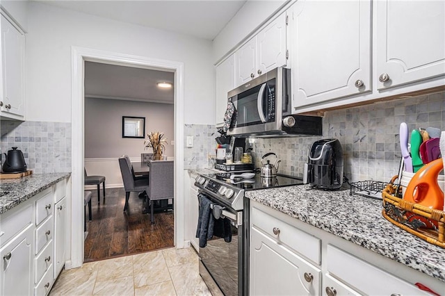 46 Le Parc Fontaine, Lithonia, GA 30038 - kitchen with stainless steel appliances, white cabinets, light stone counters, and tasteful backsplash