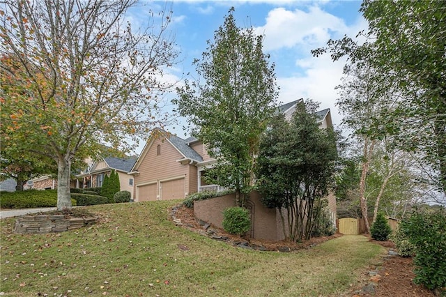 view of side of property with a lawn and a garage