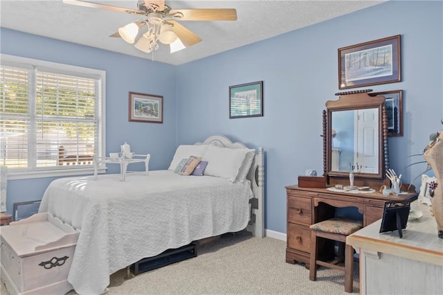 bedroom featuring carpet floors, a ceiling fan, baseboards, and a textured ceiling