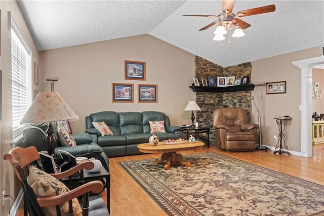 living room featuring a ceiling fan, lofted ceiling, a textured ceiling, and wood finished floors