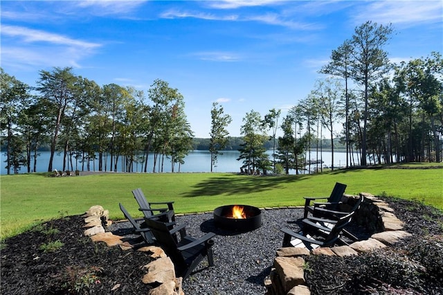 view of property's community with a yard, a water view, and a fire pit