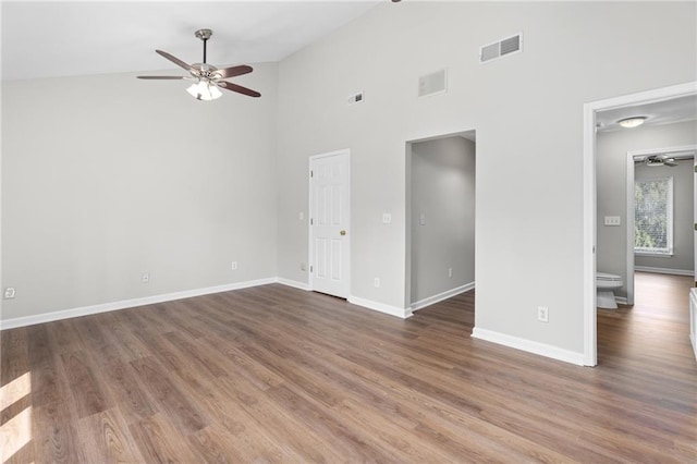 empty room with high vaulted ceiling and dark wood-type flooring