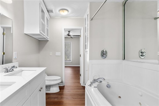 bathroom featuring a bathtub, vanity, hardwood / wood-style flooring, ceiling fan, and toilet