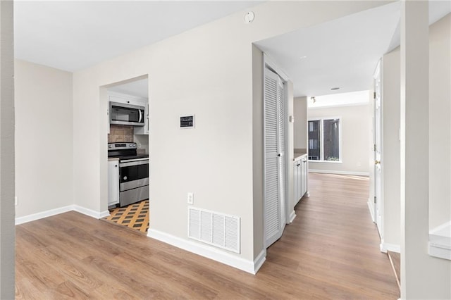 corridor with light hardwood / wood-style floors