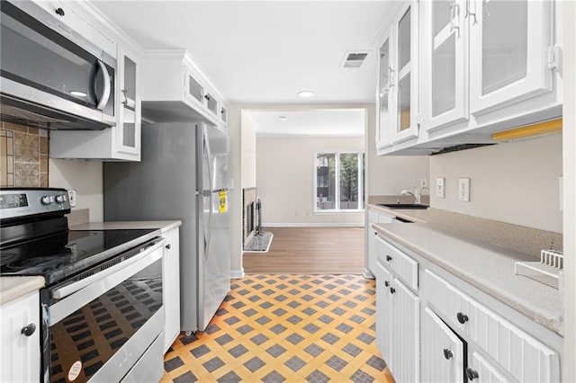 kitchen featuring white cabinets, appliances with stainless steel finishes, light hardwood / wood-style floors, and sink