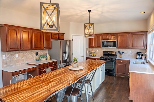 kitchen featuring sink, pendant lighting, dark hardwood / wood-style flooring, and stainless steel appliances