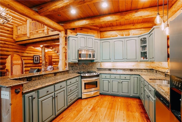 kitchen with stainless steel appliances, beam ceiling, hanging light fixtures, log walls, and wooden ceiling