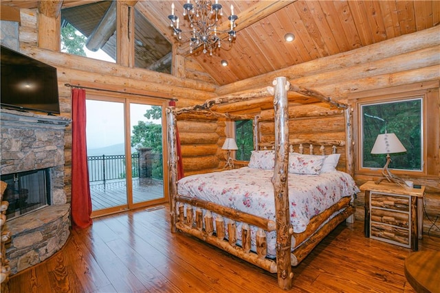 bedroom featuring access to outside, hardwood / wood-style flooring, wooden ceiling, a stone fireplace, and rustic walls