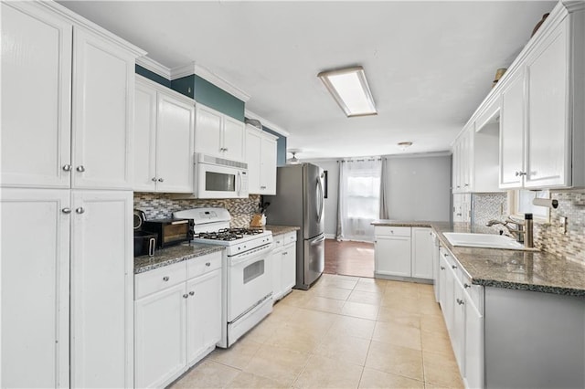 kitchen with sink, white cabinets, dark stone counters, and white appliances