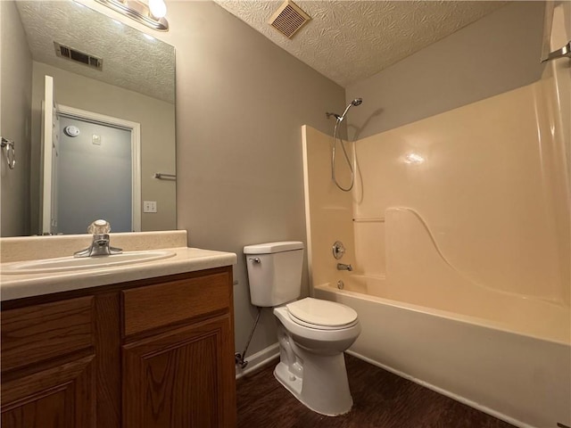 bathroom with a textured ceiling, visible vents, wood finished floors, and vanity